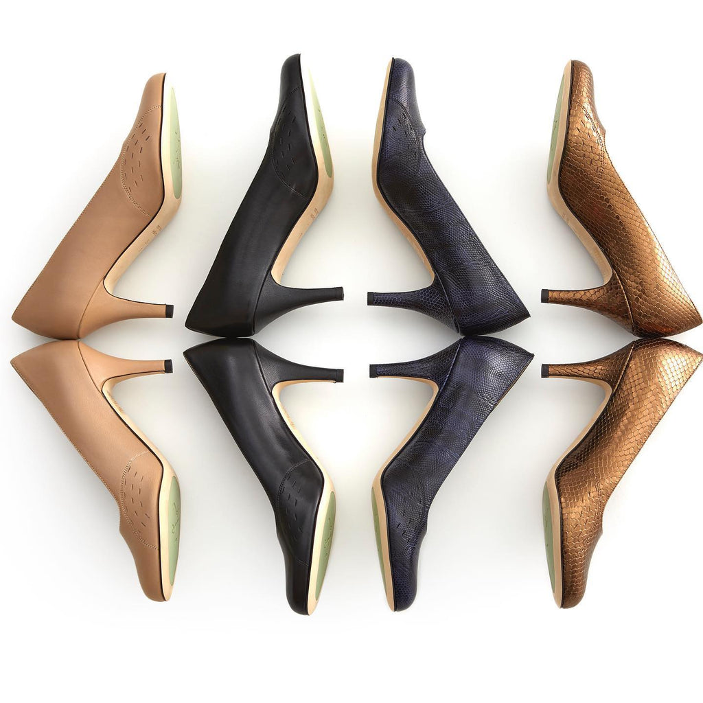 Four Kate high-heeled pumps arranged in two rows on a white background, showing different color and material options: Beige (Nude) leather, black leather, dark navy leather, and metallic bronze snakeskin. The soles are a light beige color.