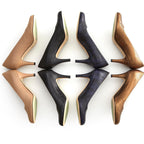 Four Kate high-heeled pumps arranged in two rows on a white background, showing different color and material options: Beige (Nude) leather, black leather, dark navy leather, and metallic bronze snakeskin. The soles are a light beige color.